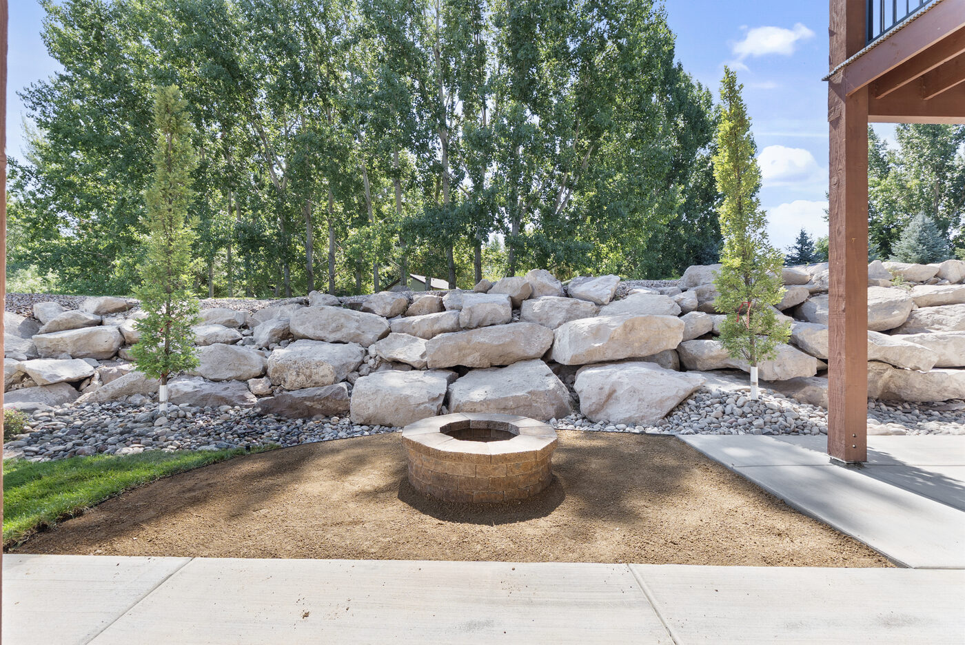 Stone fire pit with boulder retaining wall
